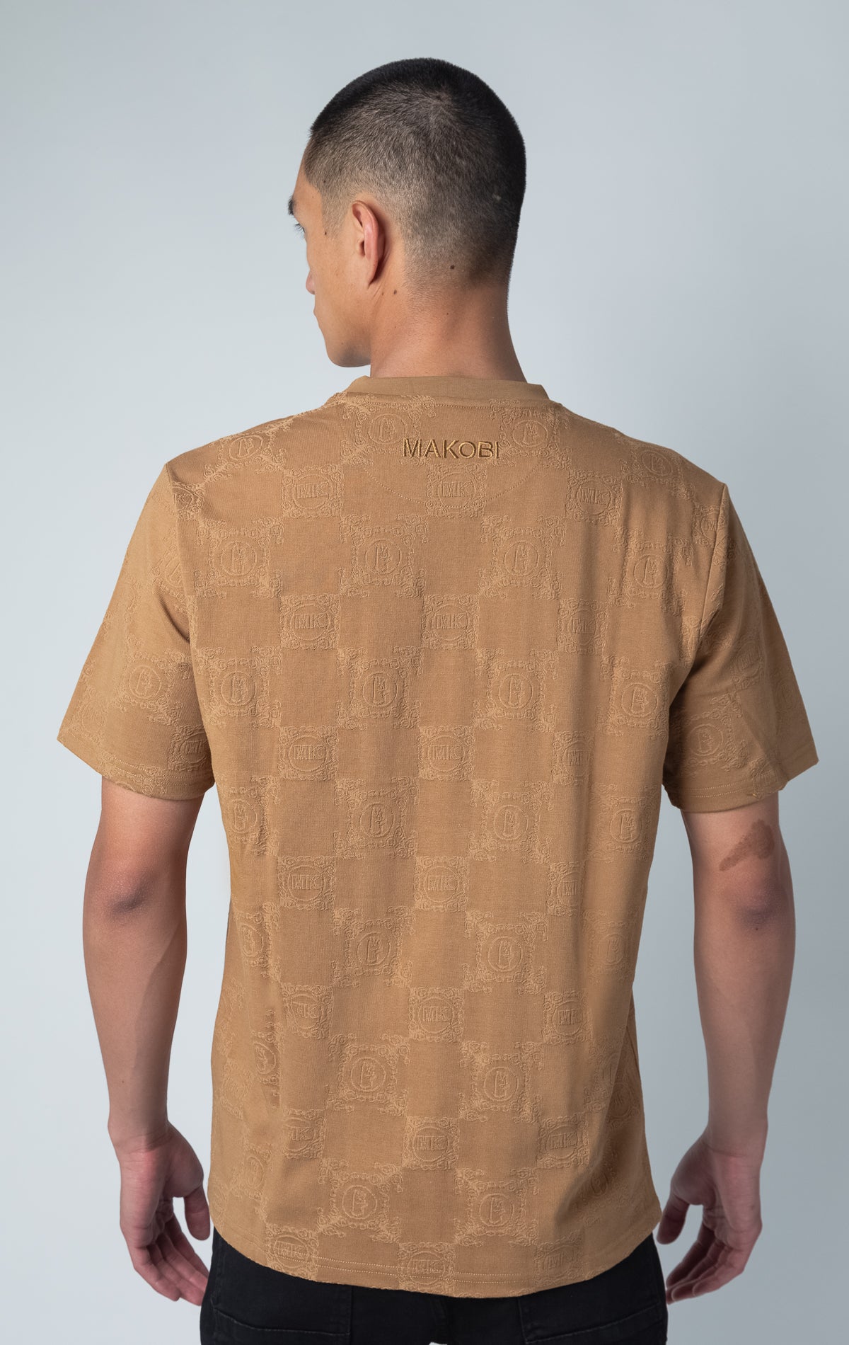 mocha all-over tonal embossed pattern, short sleeve t-shirt with Makobi embroidery on upper back