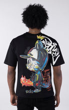 Person wearing a black t-shirt with colorful graphic design on the back against a white background