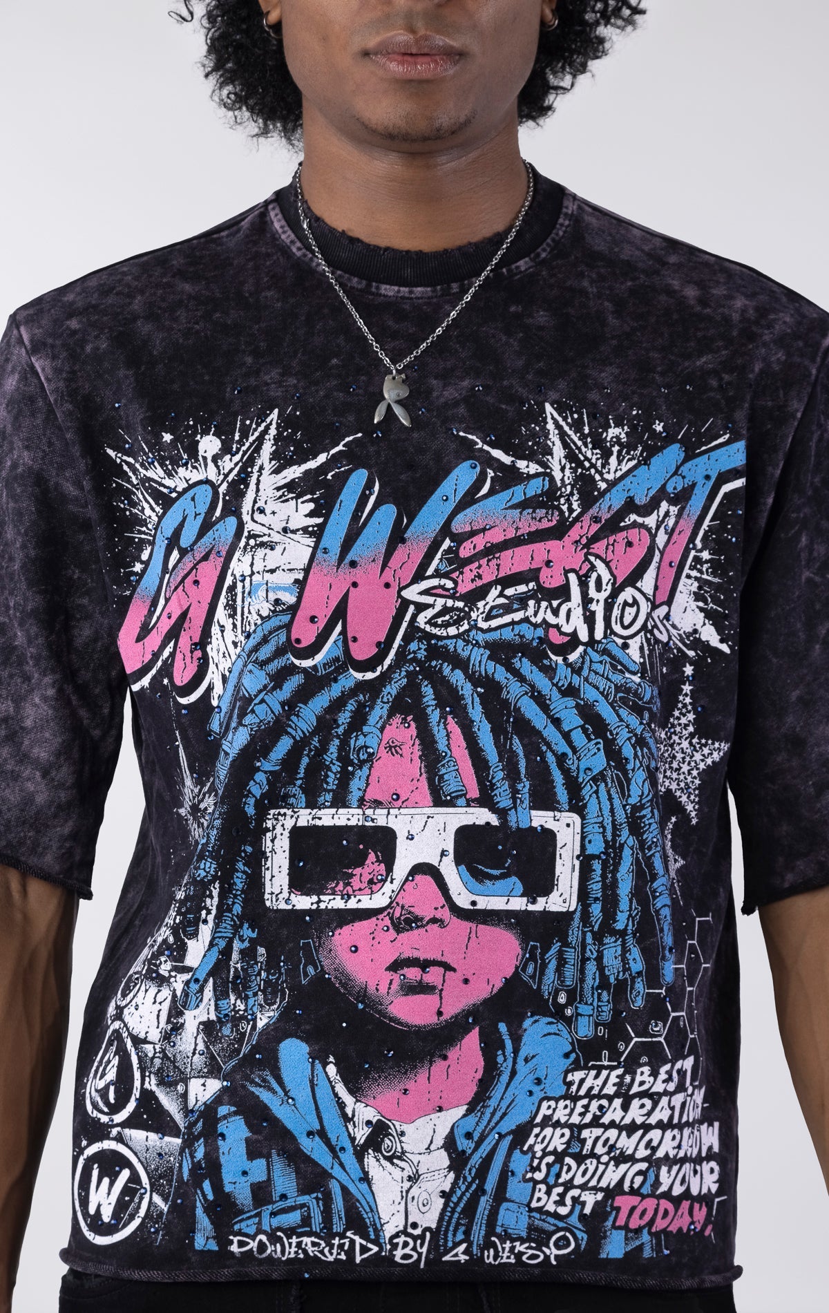 Washed black/purple oversized t-shirt featuring a large graphic of a figure with blue dreadlocks and white 3D glasses. The graphic includes the text "G-WEST Studios" and "THE BEST PREPARATION FOR TOMORROW IS DOING YOUR BEST TODAY!" accented with rhineston