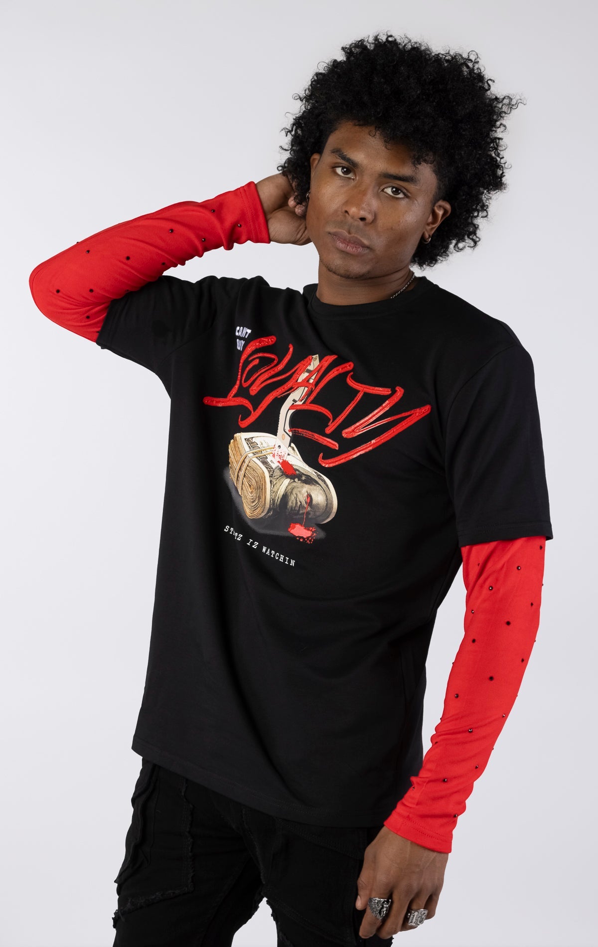 Black short-sleeve t-shirt with a red long-sleeve underneath, featuring a graphic of a stack of money stabbed by a knife and red blood. The word "LOYALTY" is printed in large red script, with "CANT BUY" and "STREETZ IZ WATCHIN" completing the design.