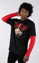 Black short-sleeve t-shirt with a red long-sleeve underneath, featuring a graphic of a stack of money stabbed by a knife and red blood. The word "LOYALTY" is printed in large red script, with "CANT BUY" and "STREETZ IZ WATCHIN" completing the design.