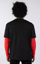 Person wearing a black t-shirt with red sleeves on a white background