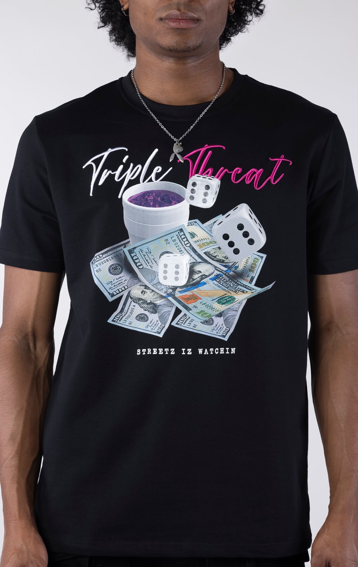 Black t-shirt with a detailed graphic featuring a pile of $100 bills, two dice, and a white cup with purple liquid. The text "Triple Threat" is printed above the image in white and pink script.
