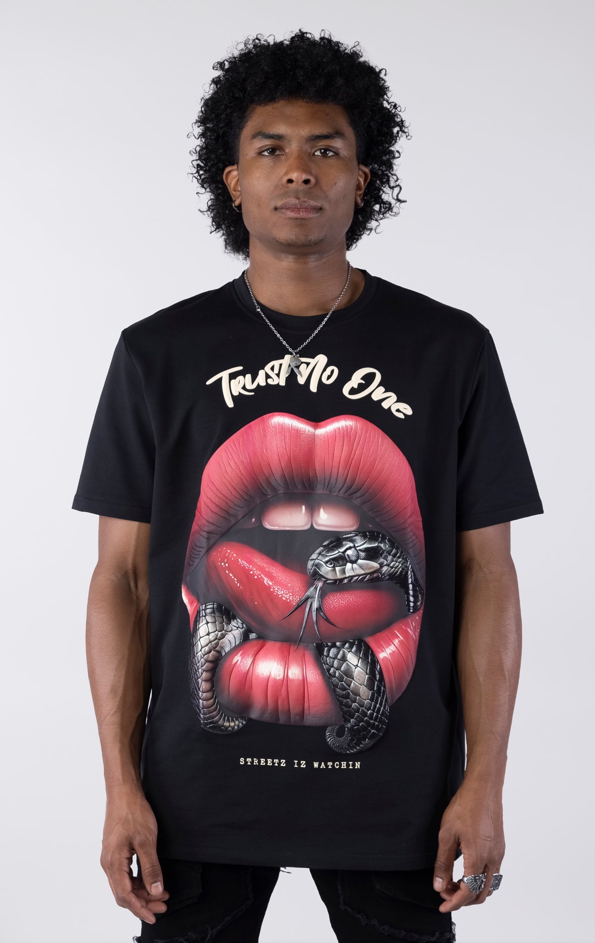 Person wearing a black t-shirt with a graphic design of red lips and a snake, text 'Trust No One' on a white background.