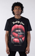 Person wearing a black t-shirt with a graphic design of red lips and a snake, text 'Trust No One' on a white background.