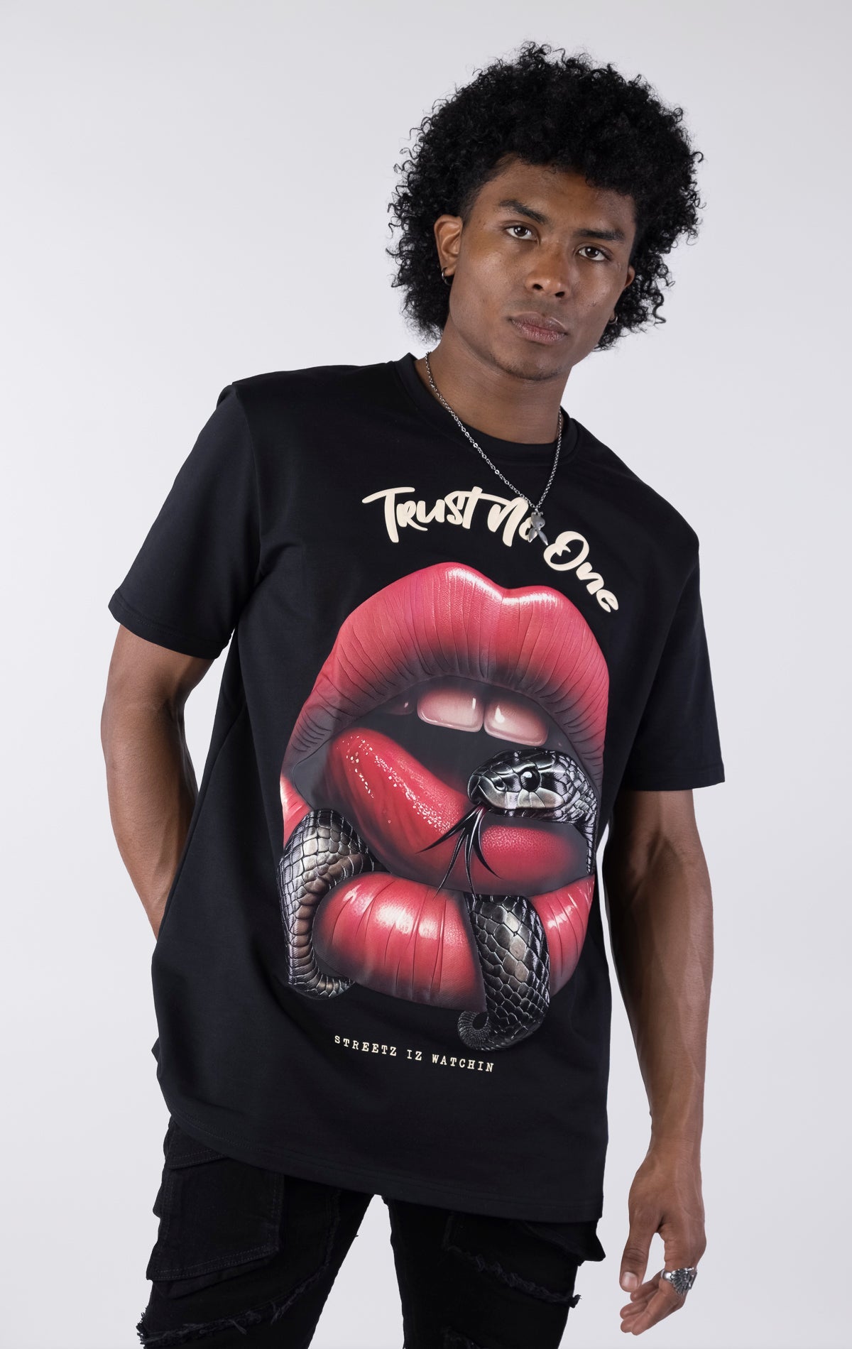 Person wearing a black t-shirt with a graphic design of red lips and a snake, text 'Trust No One' on a white background.