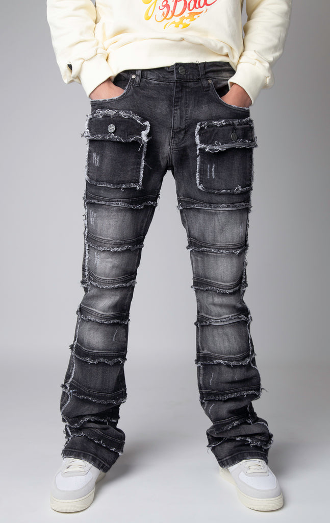 washed black Stacked denim pants, distressed and paneled with a raw finishing