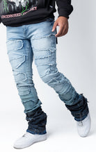 Blue distressed and stacked flare jeans featuring an ombre wash and ripped details