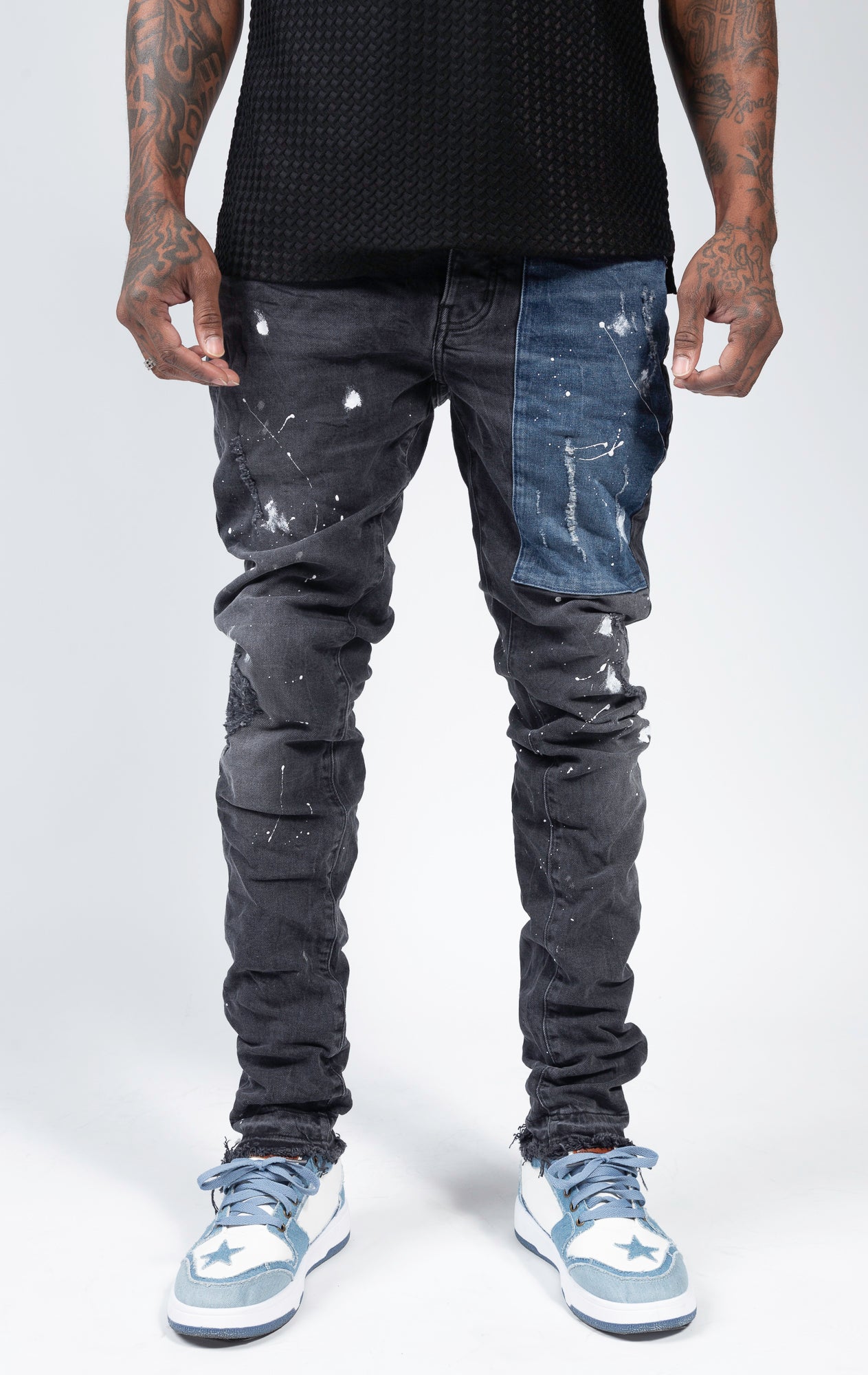 Ripped patchwork jeans with paint splatters.