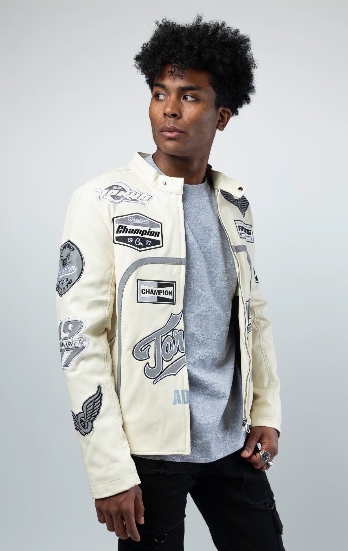 Cream Leather motorcycle jacket featuring a bold "Speedster" graphic on the back. This varsity style jacket includes ribbed cuffs and collar, and a sleek silver zipper closure
