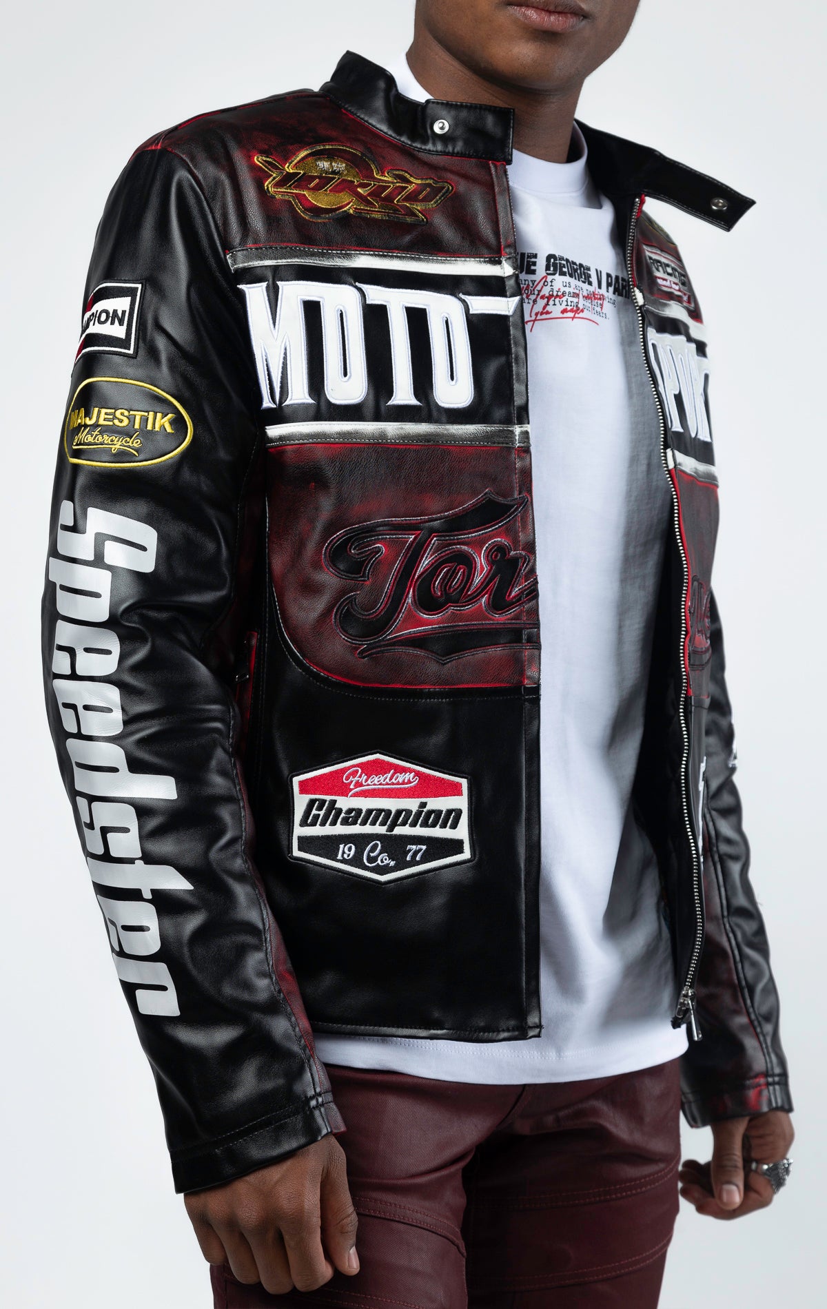 Black motor sport racing jacket with snap-button collar, full zip-up closure, multi-patch and embroidered details, zippered sleeves and pockets, and elasticized ribbed collar, cuffs, and waist. The interior includes a hanger loop, welt pocket, and faux leather finish for added convenience.