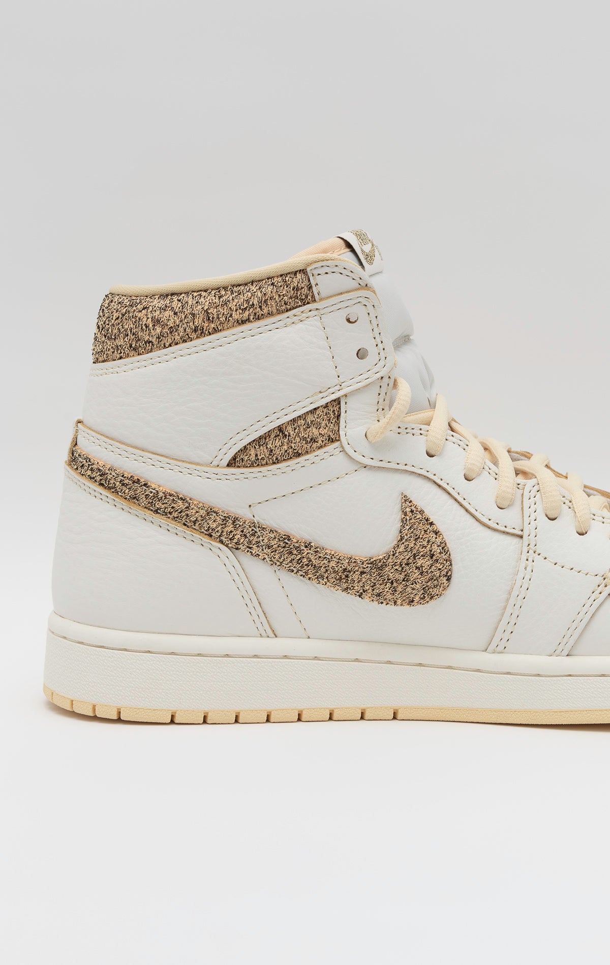 Air Jordan 1 Retro High OG Craft sneakers in Sail and Pale Vanilla premium leather with contrasting black accents and an understated pale vanilla outsole. The classic Nike Air logo adorns the tongue