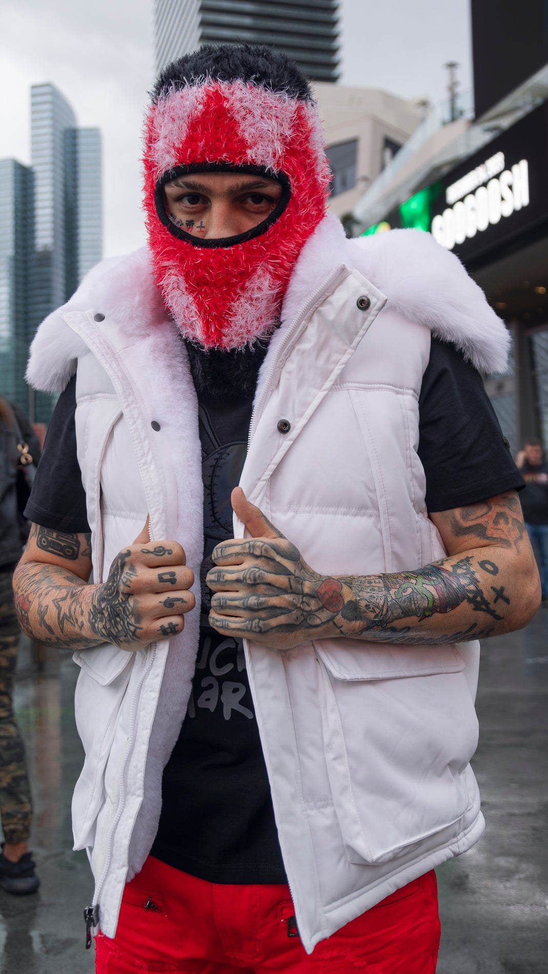 Prynce Ink wearing a Faux fur-lined hooded jacket made of a water-resistant polyester shell featuring a removable hood with a removable faux fox fur trim. The hood and front of the jacket are lined with faux rabbit fur for superior warmth. The jacket has JC branded zippers throughout, dual pockets at the sides with button openings, and a full zipper front opening. Faux suede taping adorns the front zipper.