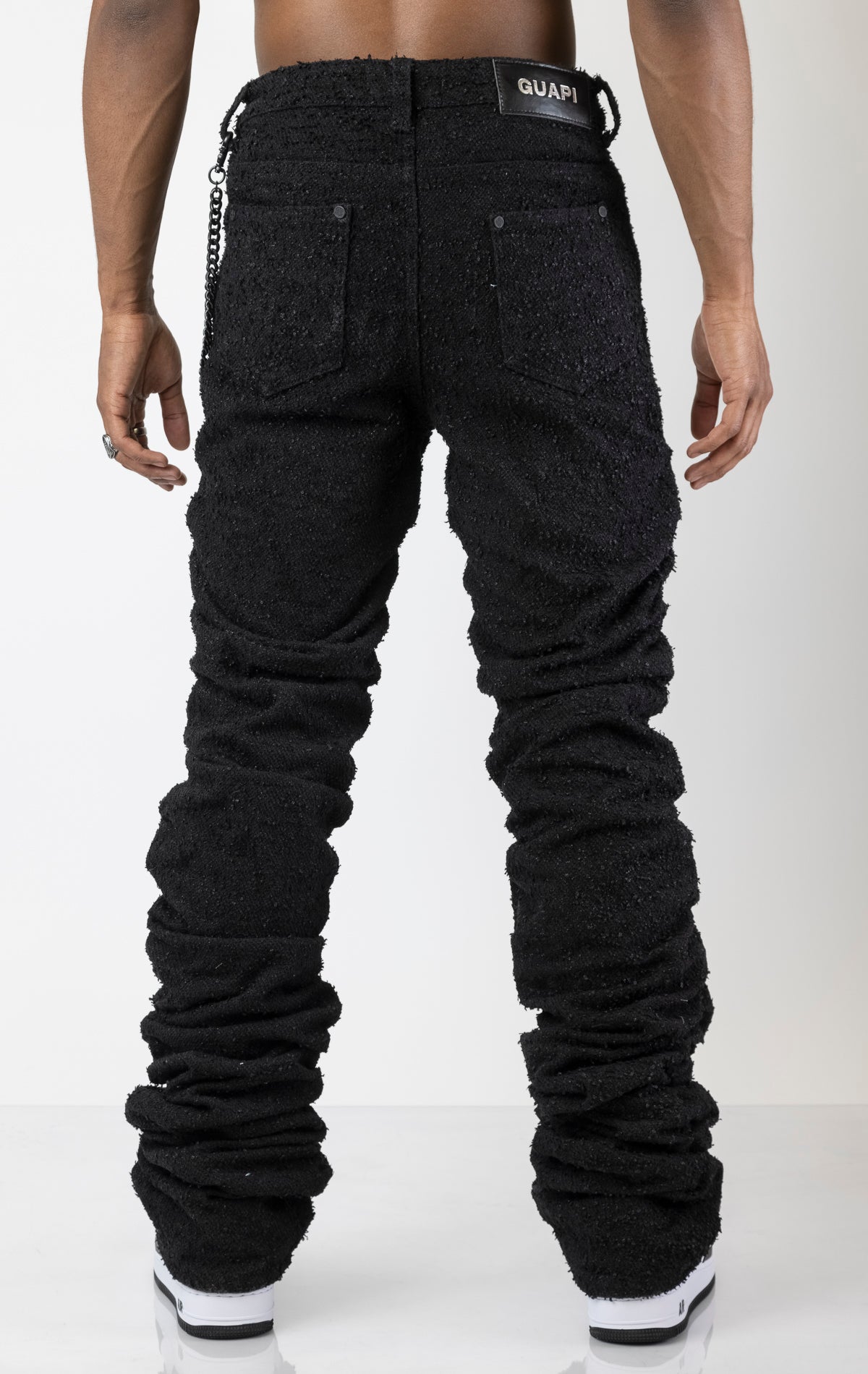 Men's jeans in a dark wash with a unique stacked design that starts from the thigh. The jeans taper at the ankle for a slim fit and feature custom hardware. Made from a blend of 80% cotton and 20% polyester. 
