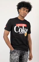 Men's black short-sleeve t-shirt in a classic fit. The shirt features Coca-Cola logos and images screen-printed on both the front and the back.