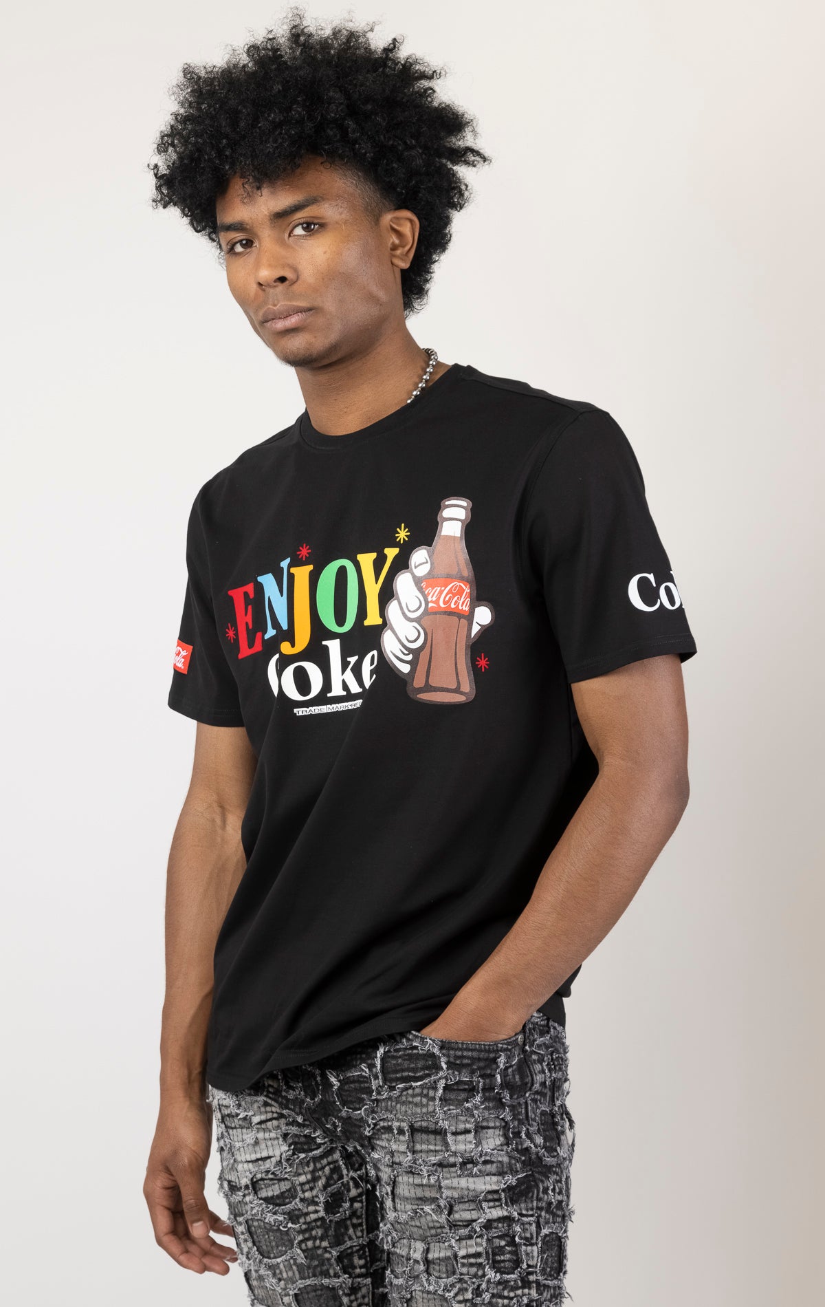 Men's black short-sleeve crew neck t-shirt in a variety of colors. The shirt features a Coca-Cola logo graphic on the front. The graphic is heat-sealed and the tee is made from a blend of 94% cotton and 6% spandex.