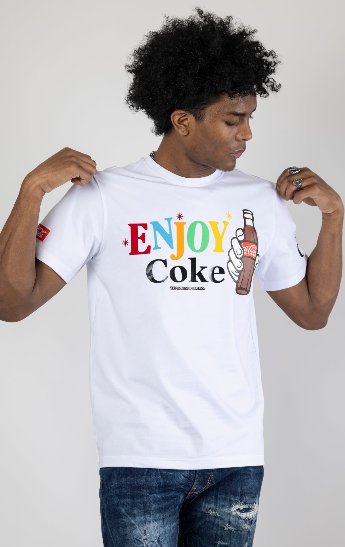 Men's white short-sleeve crew neck t-shirt in a variety of colors. The shirt features a Coca-Cola logo graphic on the front. The graphic is heat-sealed and the tee is made from a blend of 94% cotton and 6% spandex.