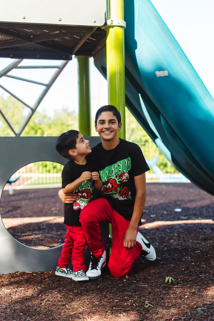 Two kids wearing sneakerhead t shirts and red stacked pants