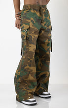 Men's baggy cargo pants in camo. The pants feature a wide, relaxed fit from the waist down, paneled construction, spacious cargo pockets with loop closures and functional tightening straps, and custom hardware. Made from a blend of 98% cotton and 2% spandex.