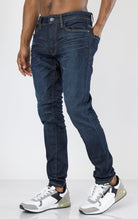 Men's Sean Slim Taper jeans in dark indigo. The jeans feature a regular rise waist, a comfortable fit from waist to thigh, a slim taper from knee to ankle, 3D baked wrinkles for texture, a raw denim look, and are made from a super stretch fabric blend (35