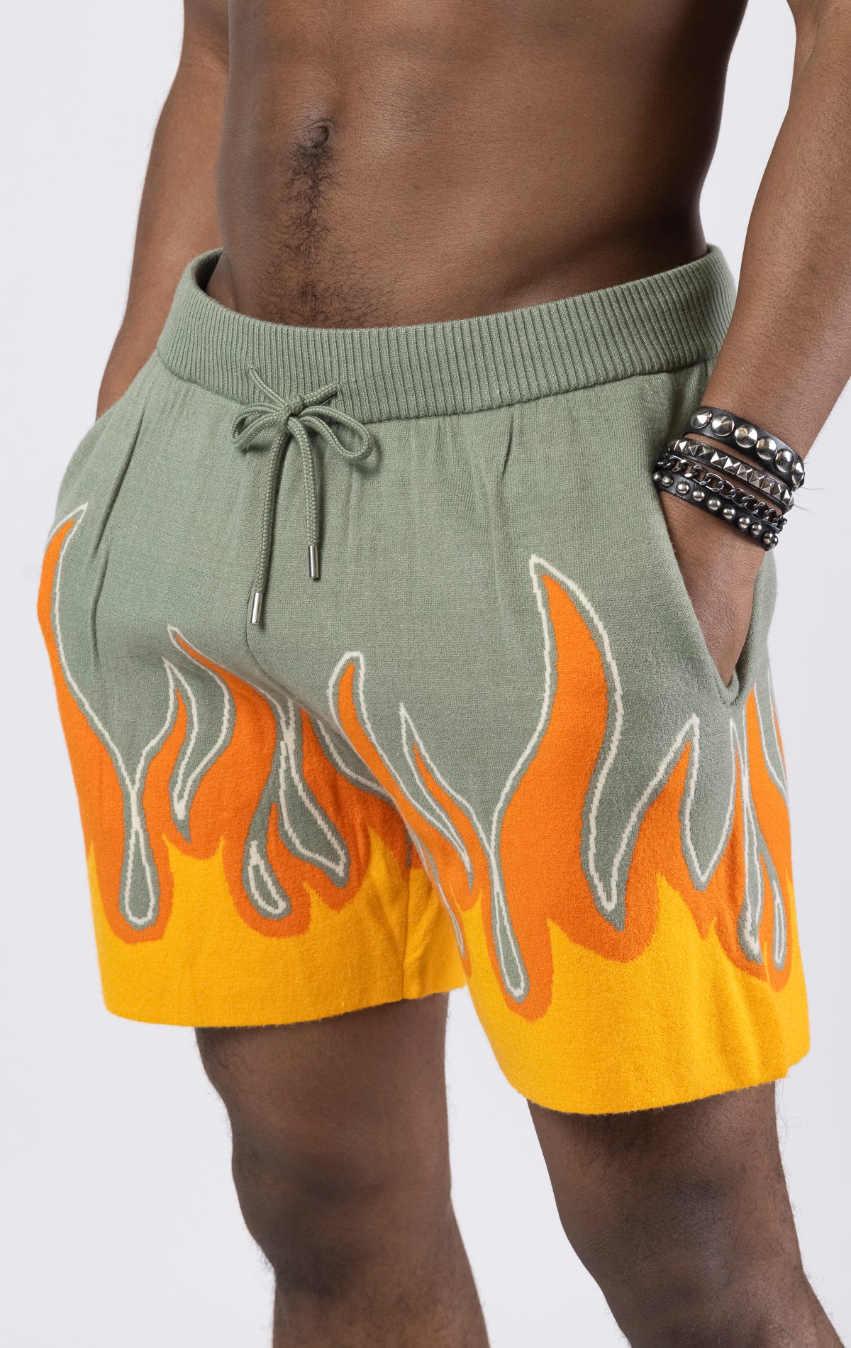 Sprayground Flame Sweater Shorts in sage green. Made from a soft and comfortable sweater material, these shorts feature a bold flame design on the bottom.