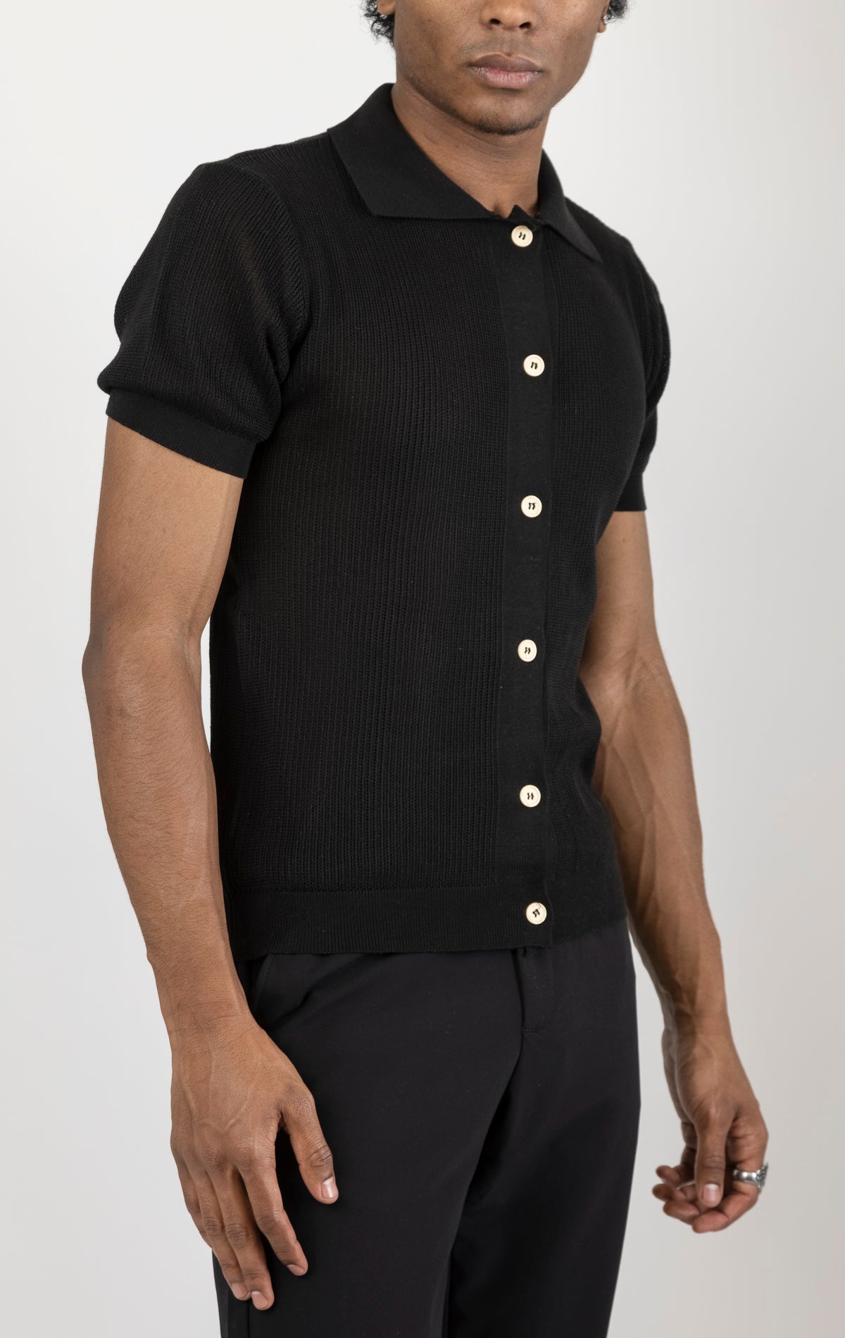 Men's see-through button-down mesh top in black. The top is made from a 50% cotton, 50% acrylic blend and features a tailored fit with a sheer mesh fabric and button-down closure.