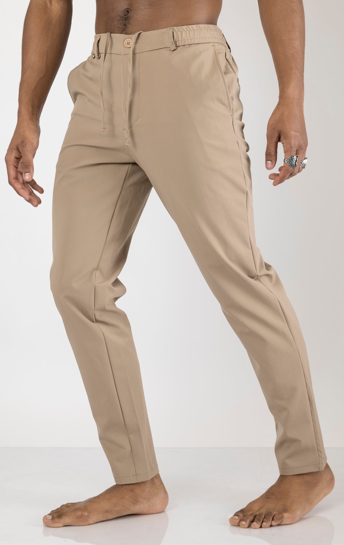 Men's wrinkle-free tapered travel pants in camel color. The pants are made from a blend of polyamide (88%) and elastane (12%) and feature a tapered fit, wrinkle-resistant fabric, and multiple pockets.