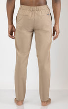 Men's wrinkle-free tapered travel pants in camel color. The pants are made from a blend of polyamide (88%) and elastane (12%) and feature a tapered fit, wrinkle-resistant fabric, and multiple pockets.