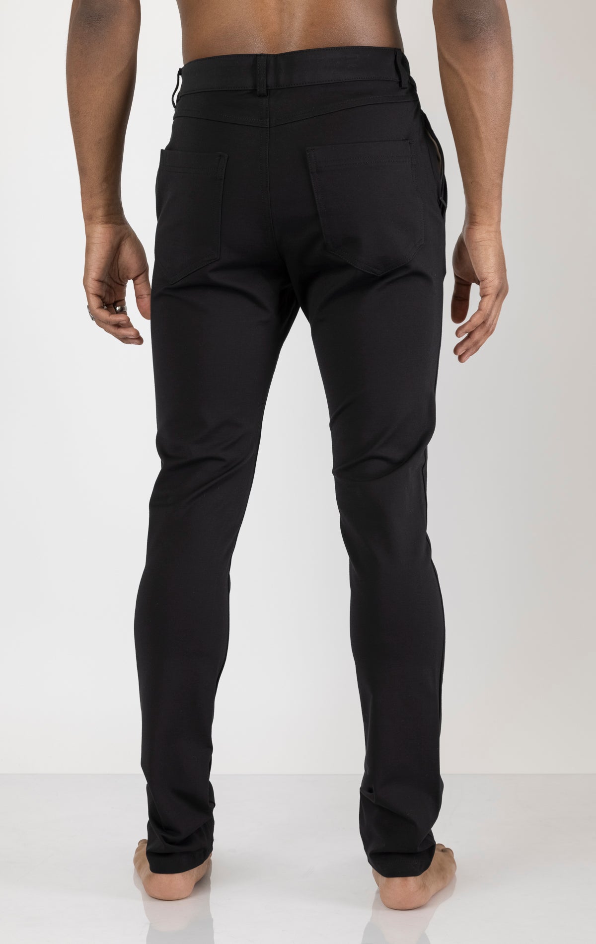 Men's casual wear pants in black. The pants are made from a blend of rayon (65%), nylon (27%), and elastane (8%) and feature a classic design with straight or tapered legs, belt loops, pockets, and a zip fly with button closure.