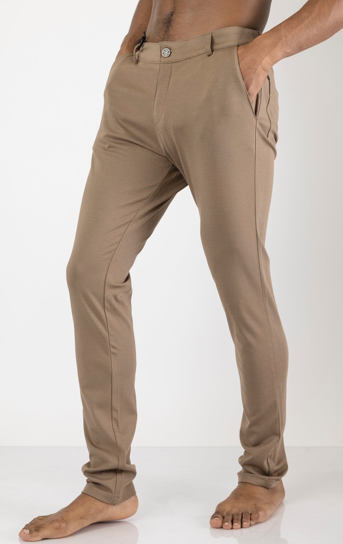 Men's casual wear pants in camel. The pants are made from a blend of rayon (65%), nylon (27%), and elastane (8%) and feature a classic design with straight or tapered legs, belt loops, pockets, and a zip fly with button closure.