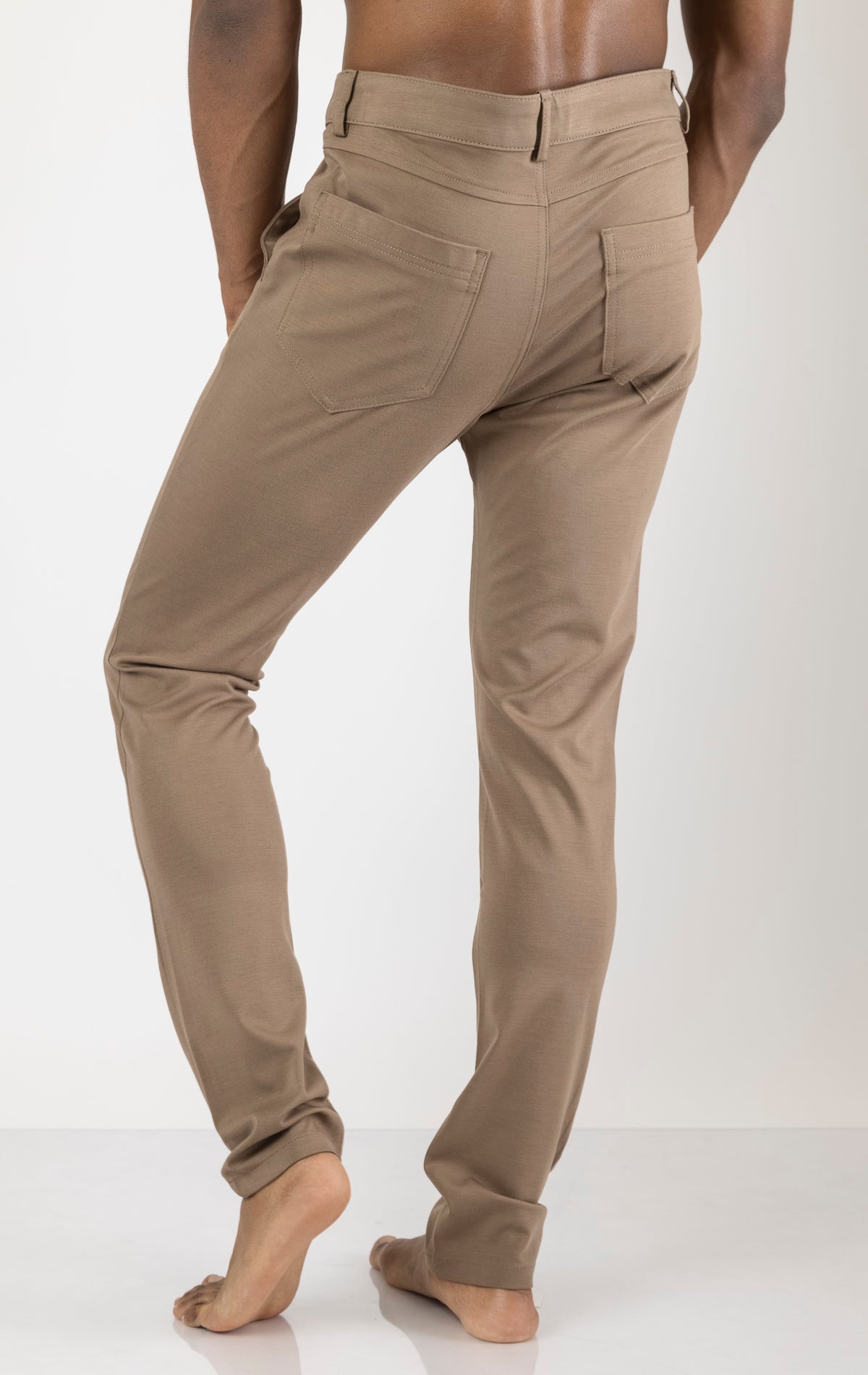 Men's casual wear pants in camel. The pants are made from a blend of rayon (65%), nylon (27%), and elastane (8%) and feature a classic design with straight or tapered legs, belt loops, pockets, and a zip fly with button closure.