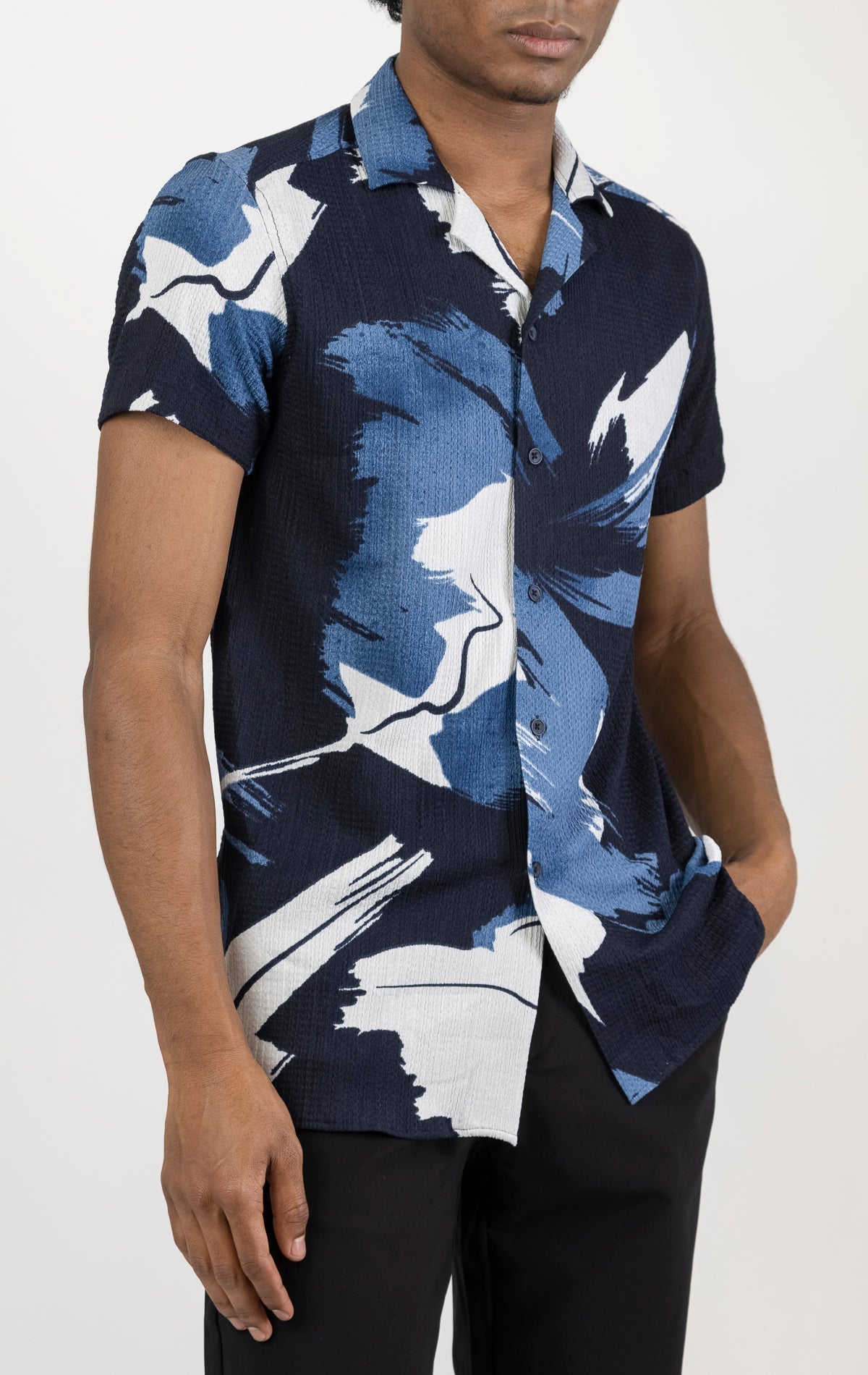 Men's short sleeve geometric pattern shirt in blue. The shirt is made from a lightweight and breathable fabric (99% polyester, 1% elastane) and features a relaxed fit, short sleeves, a classic collar, and a button-up front closure.