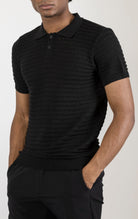 Men's eyelet short sleeve polo tee in Black . The shirt is made from a soft and breathable fabric (50% viscose, 50% polyamide) and features a classic polo collar, short sleeves, and delicate eyelet detailing along the sleeves.