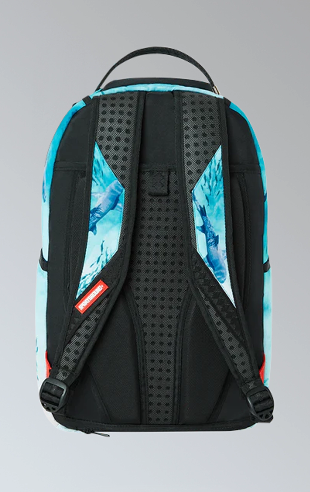 Sprayground backpack with shark graphic, gold zippers and metal hardware featuring multiple compartments and pockets, including a separate velour laptop compartment and a velour sunglass compartment. It has ergonomic mesh back padding, adjustable straps, and a slide-through back sleeve for attaching to carry-on luggage.  The backpack is made from durable 900D polyester fabric.