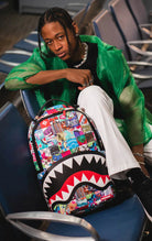 Striking colorful checkered Sprayground backpack with separate laptop & sunglasses compartments, padded back, and luggage sleeve.