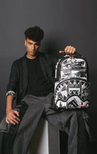 Sleek black Sprayground backpack with inverted comic book graphics, featuring separate velour laptop & sunglass compartments, padded back, and luggage sleeve.