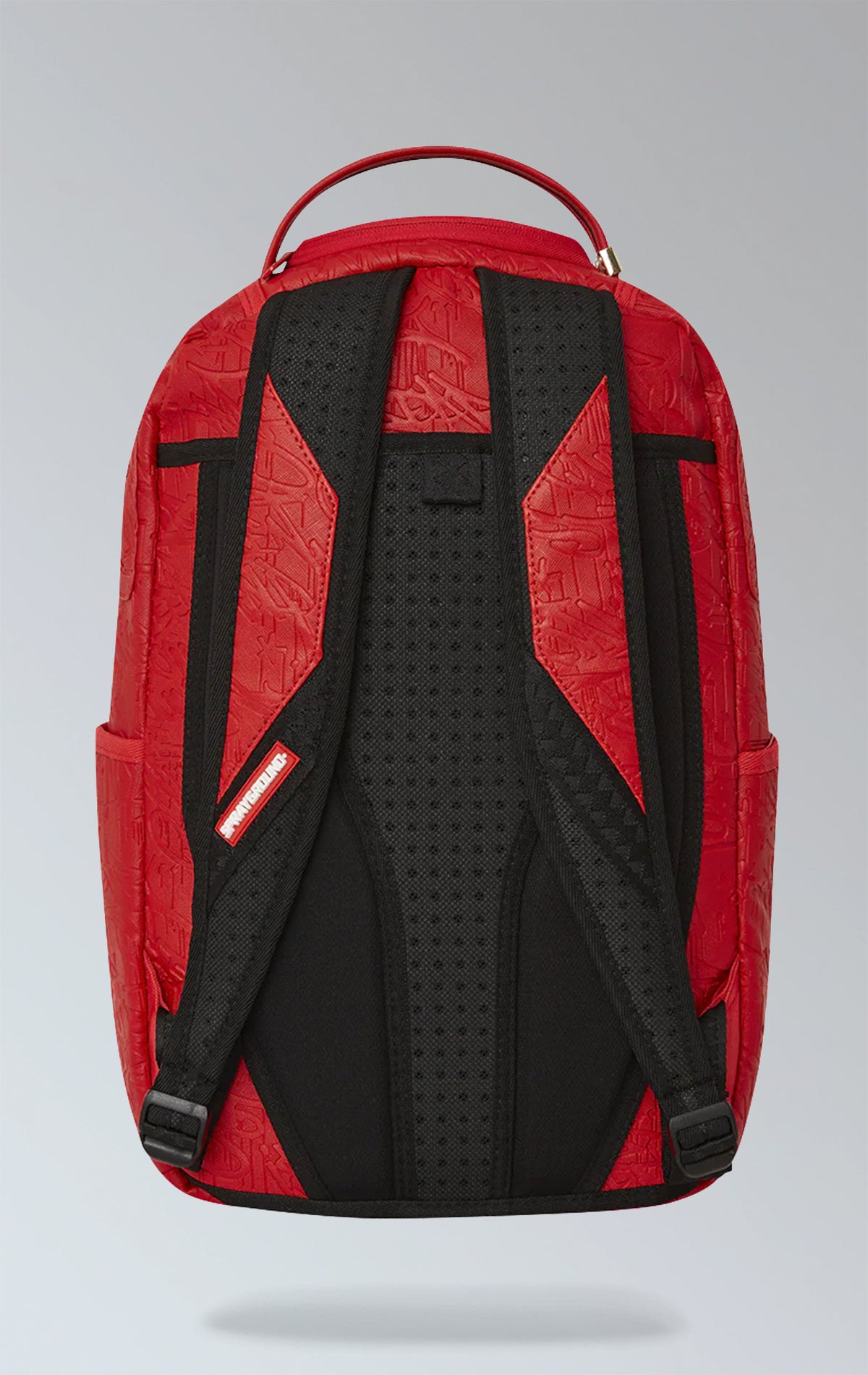 Red Sprayground backpack with an eye-catching scribble design. Features multiple compartments including a separate velour laptop compartment, side pockets, and a hidden zippered pocket. Equipped with ergonomic mesh back padding, adjustable straps, and a sliding back sleeve for attaching to carry-on luggage. Made from durable vegan leather.