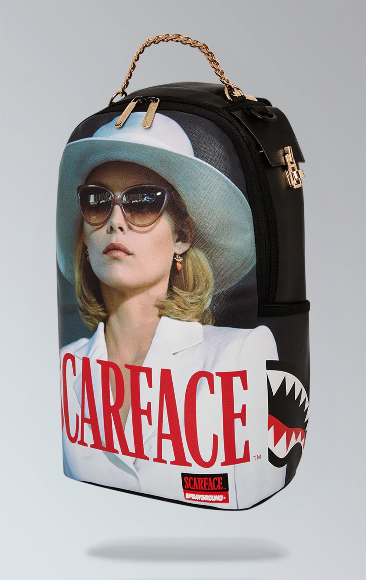 SCARFACE MICHELLE PFEIFFER BACKPACK. Exterior: Measurements: 18" x 6" x 11.5" Front zip pocket, side pockets, stash pocket with zipper. Separate compartment for sunglasses with velour lining, comfortable padded mesh back. Flexible straps for personalized fit. Gold zippers and metal hardware. "Sprayground Authentic" badge in metal. Back sleeve with strap attaches to carry-on luggage for hands-free travel.