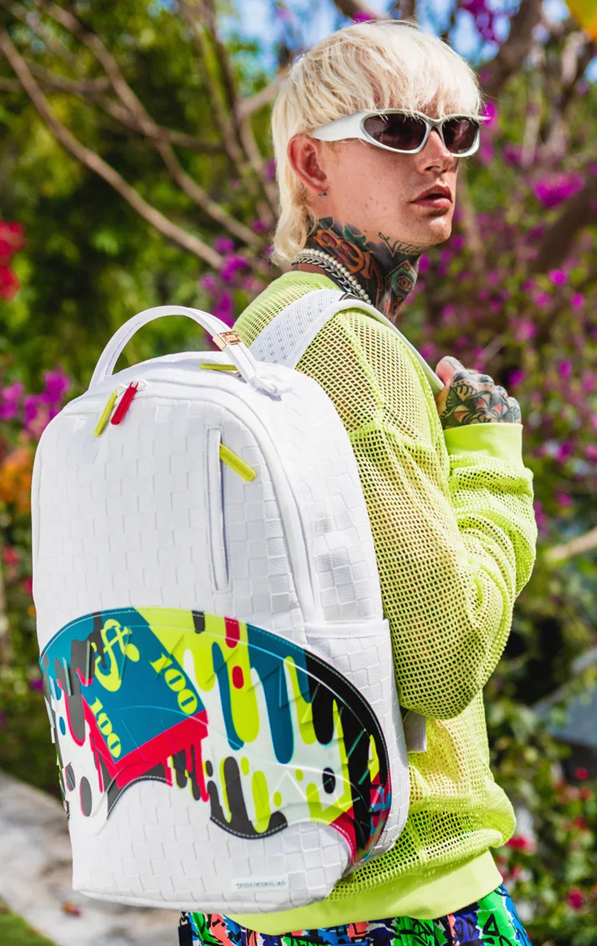 Cool white Sprayground backpack featuring a stylized shark graphic, with separate velour laptop & sunglass compartments, padded back, and luggage sleeve.