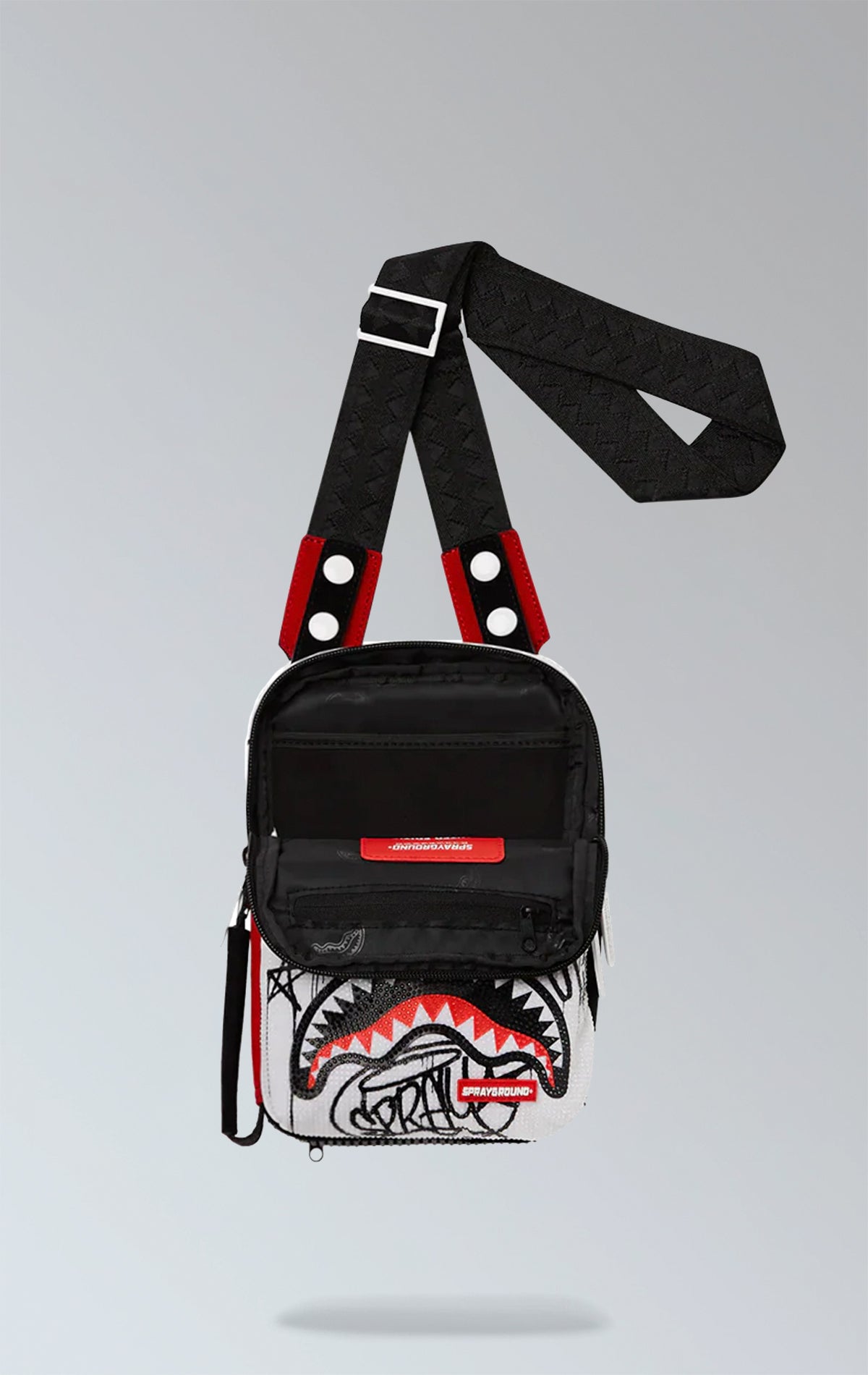 Red Sprayground Vandal Trinity sling bag in durable vegan leather, perfect for essentials like phone, wallet, and sunglasses. Features two front zipper pockets, one back pocket, and side handle.