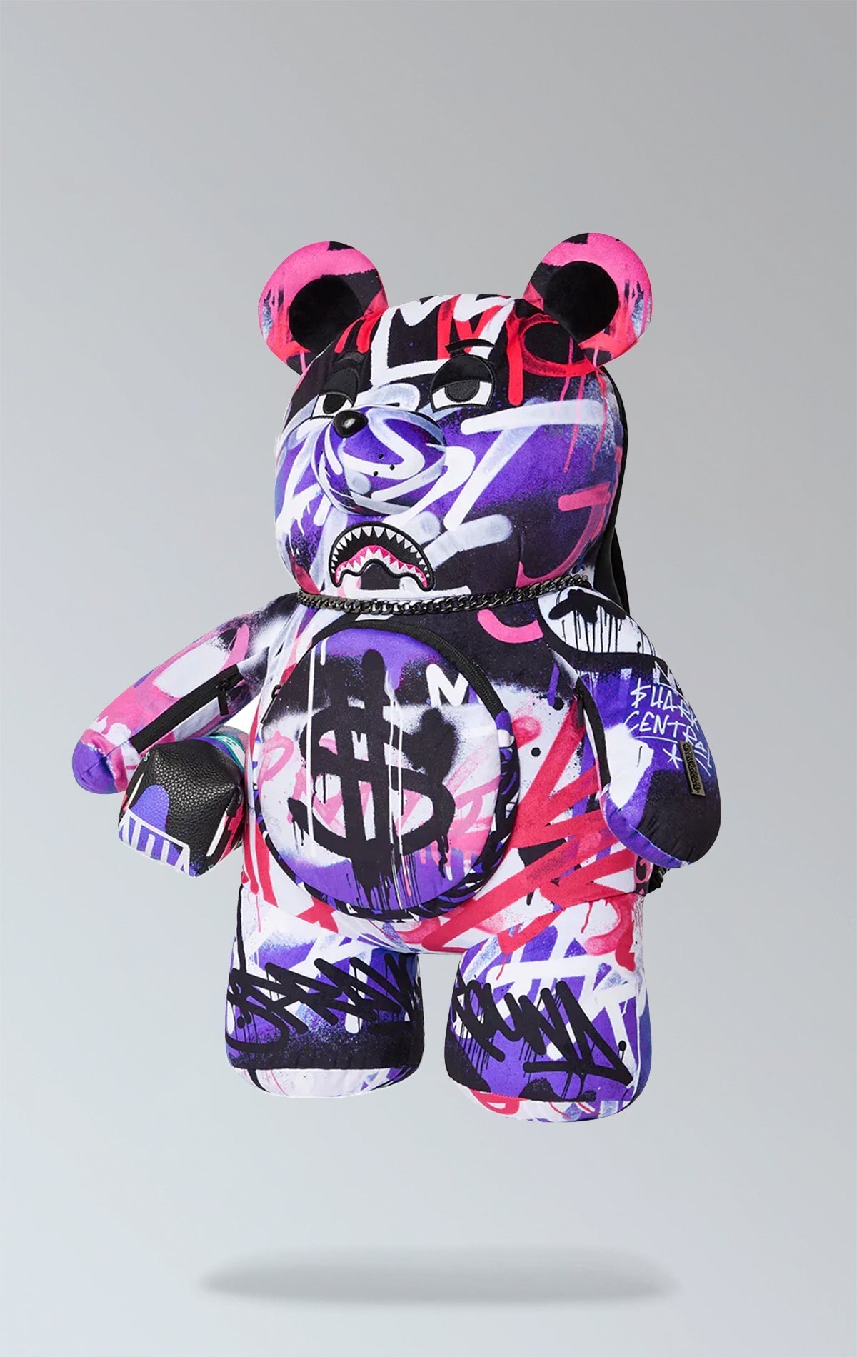 Sprayground purple backpack with Money Bear design, featuring a zippered pocket on the belly, zippered pockets on each arm, a large zippered pocket on the back panel, and adjustable straps. Made from durable water-resistant polyester velour fabric.