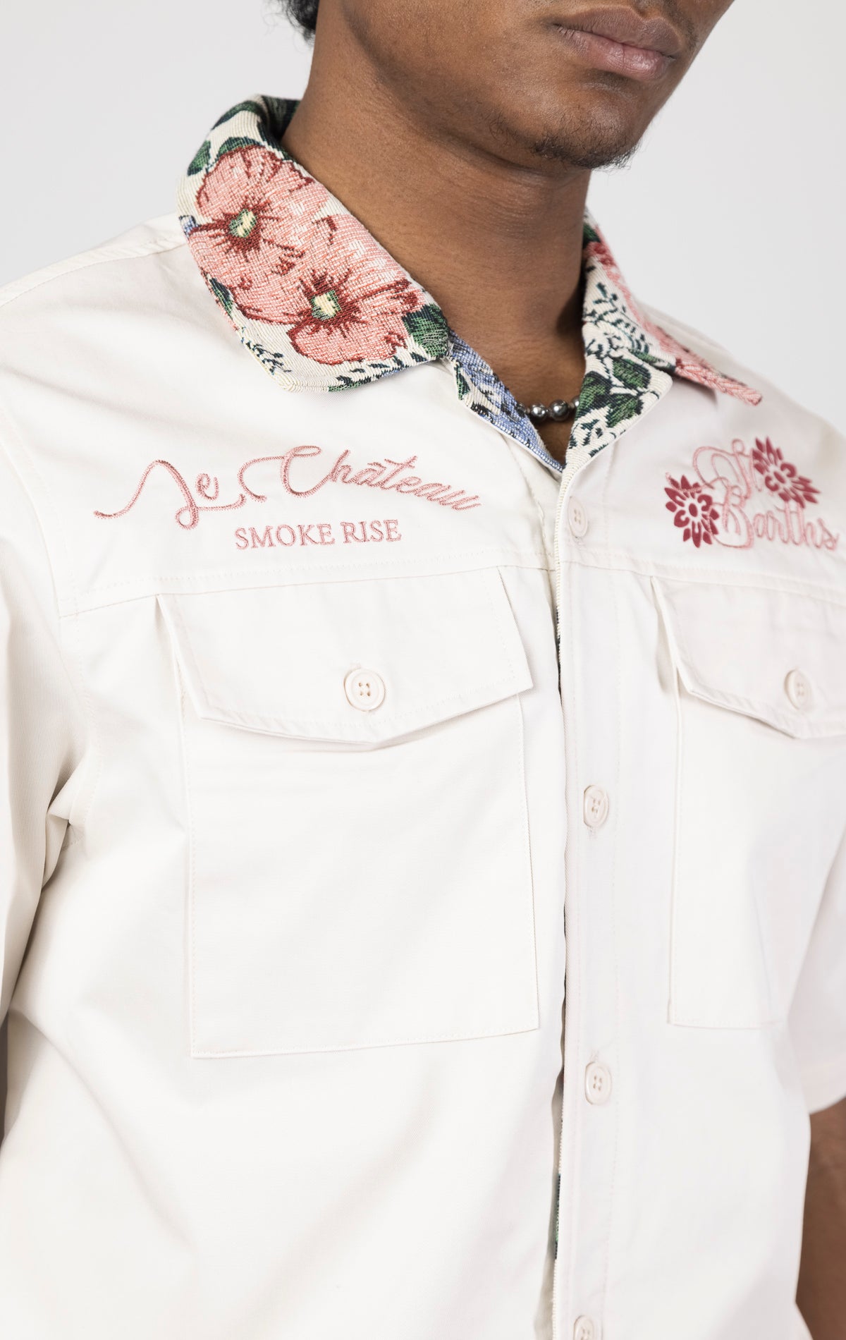 Men's short-sleeve button-up shirt in either chalk. The shirt features a tapestry design on the back with complementary embroidery details. Made from 100% cotton. The fit is regular.