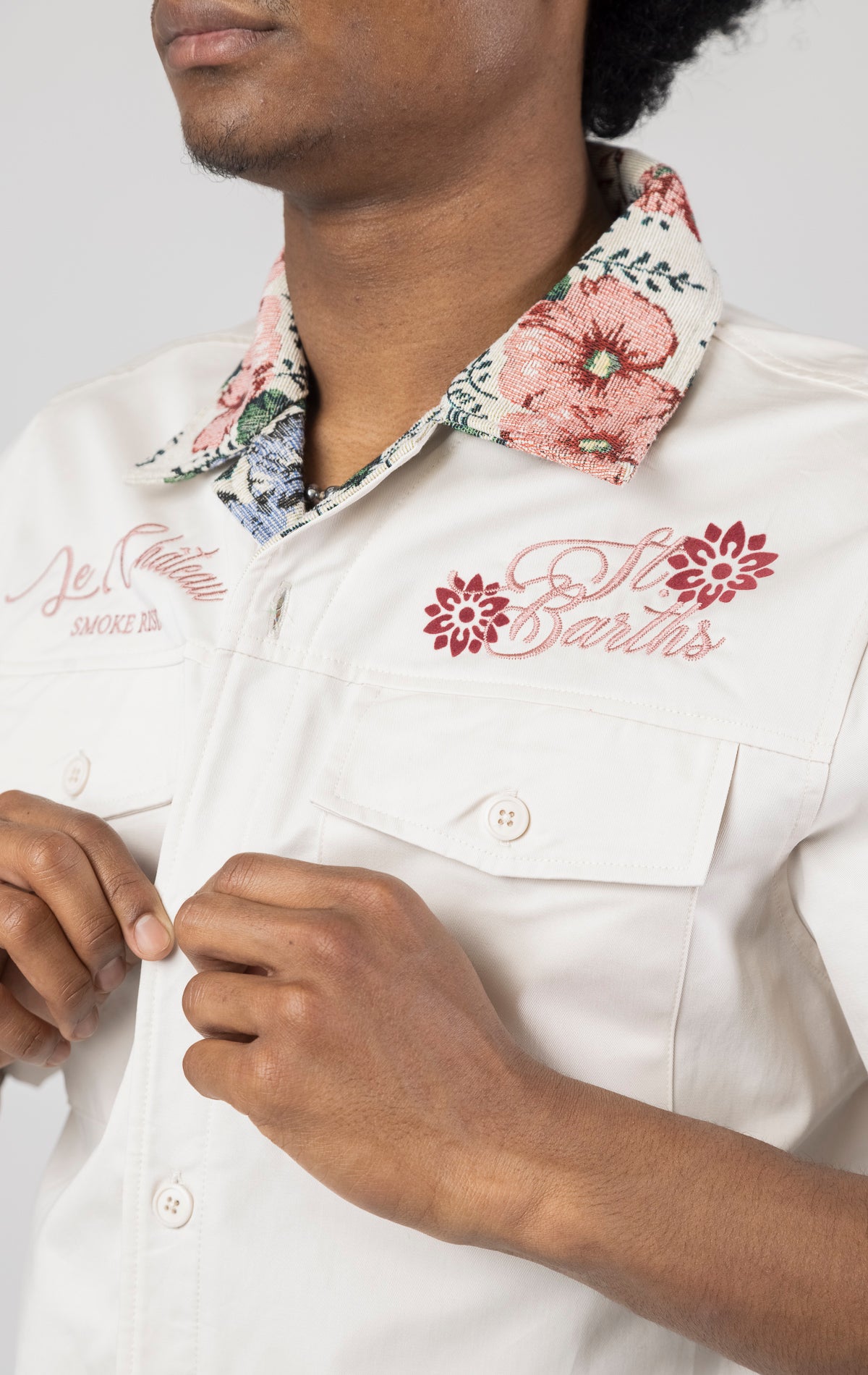 Men's short-sleeve button-up shirt in either chalk. The shirt features a tapestry design on the back with complementary embroidery details. Made from 100% cotton. The fit is regular.