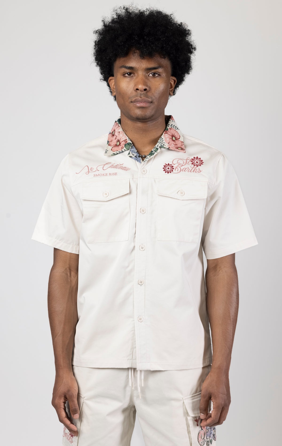 Men's short-sleeve button-up shirt in either chalk. The shirt features a tapestry design on the back with complementary embroidery details. Made from 100% cotton. The fit is regular.