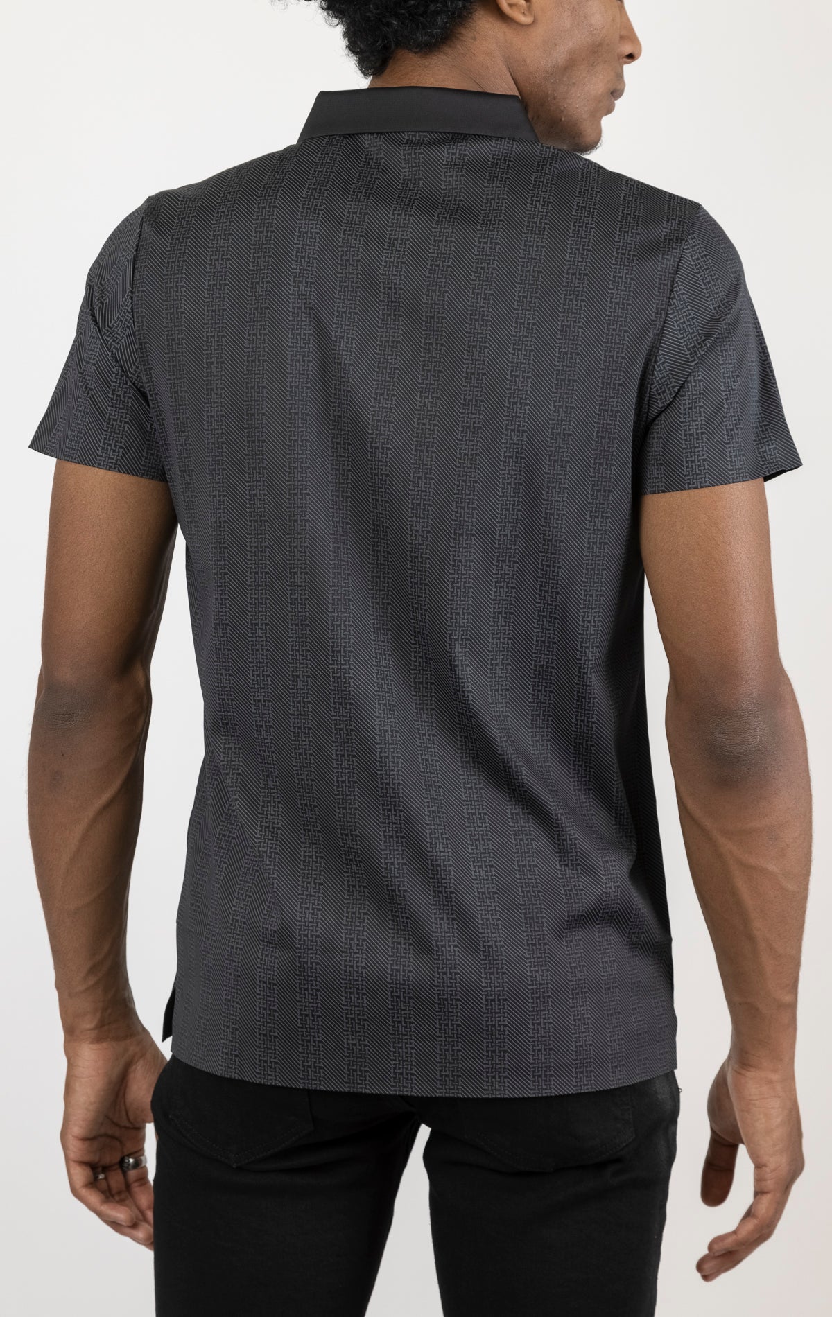 Men's versatile stretch polo shirt in black. The polo is made from an 87% nylon, 13% spandex blend and features a seamless pattern design, a classic polo collar with buttons, and short sleeves.